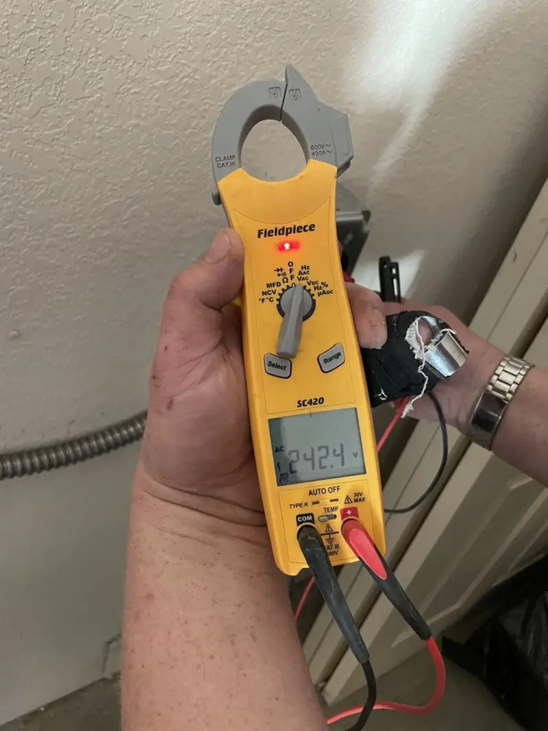 Voltage testing with clamp meter during Ceiling Fan Installation in University